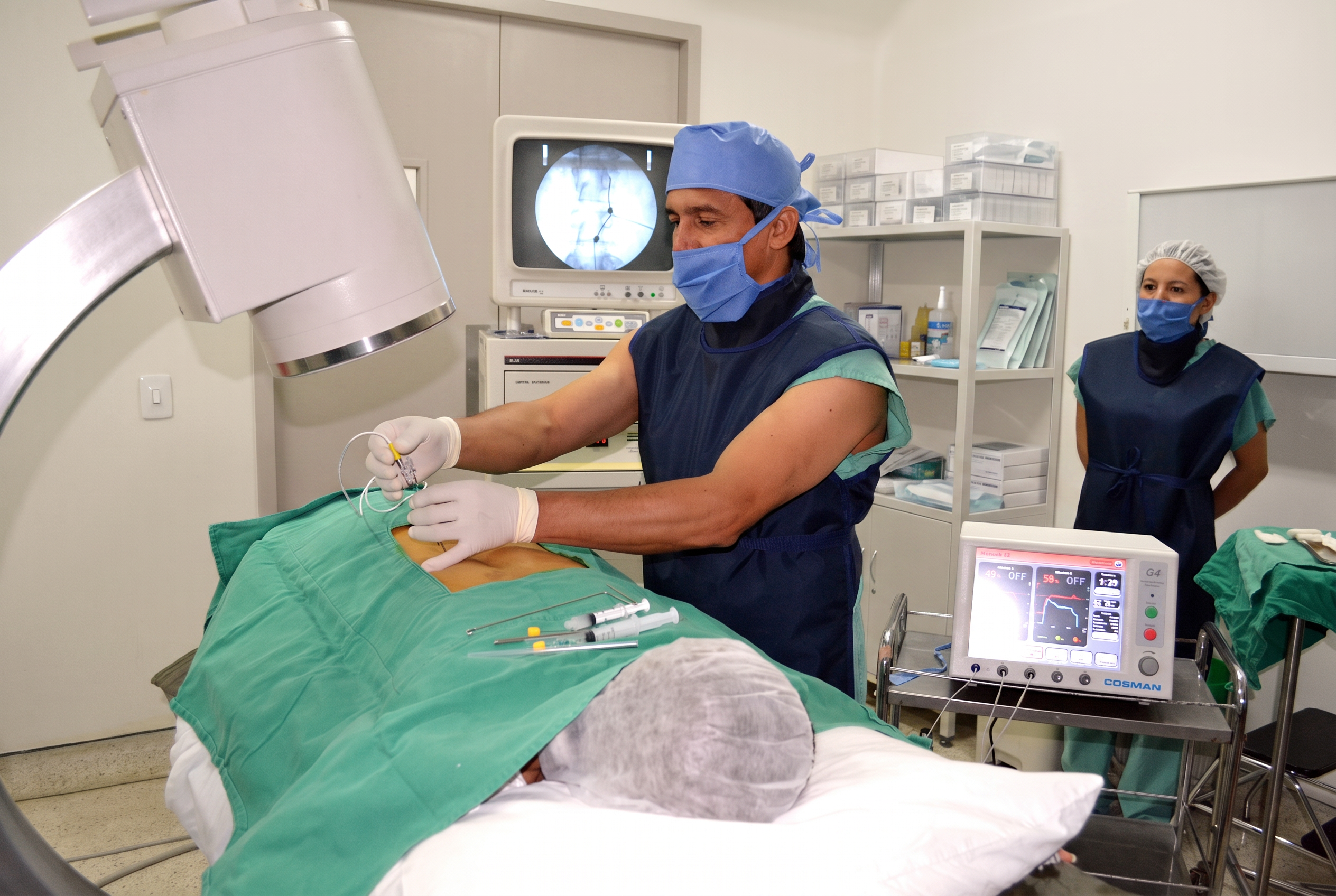Dr. René Rodríguez durante un procedimiento de radiofrecuencia, atento al paciente.